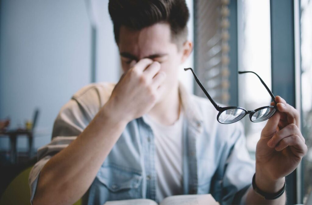  person rubbing their eyes due to a combination of dry eye and astigmatism symptoms.