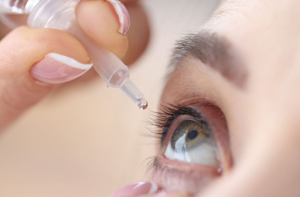 Close-up of an eye dropper dropping into an open olive eye.