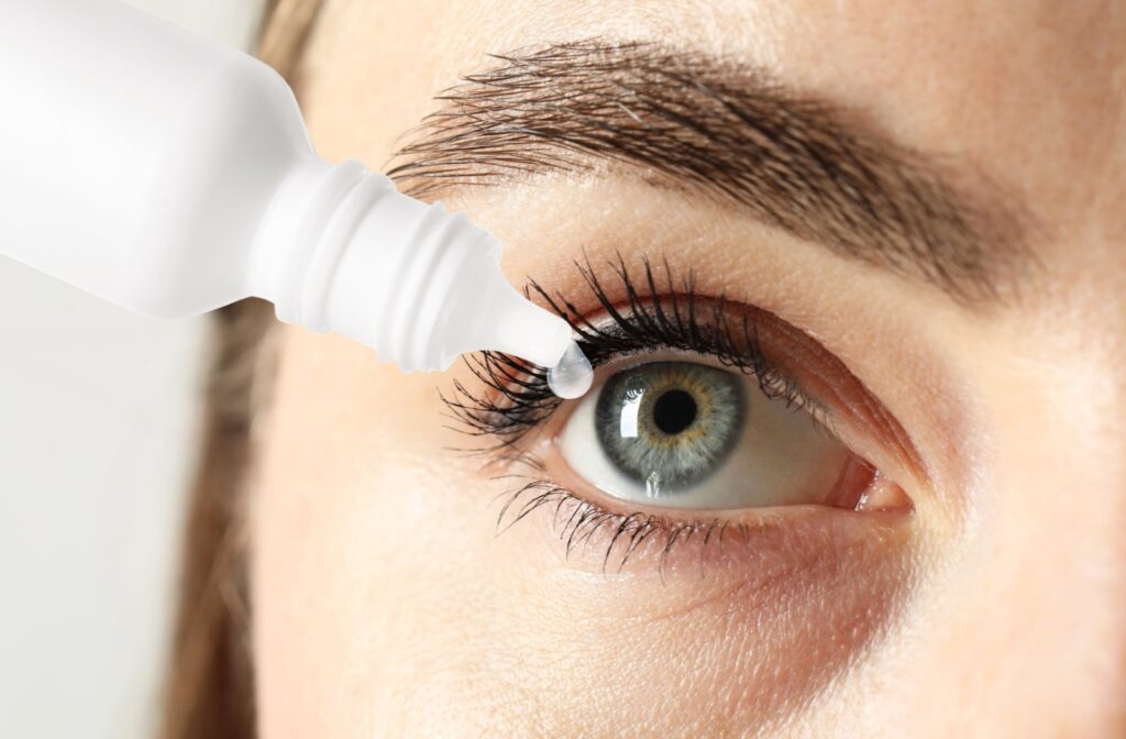 A close-up image of someone putting eye drops in their eye to counter the symptoms of MGD.