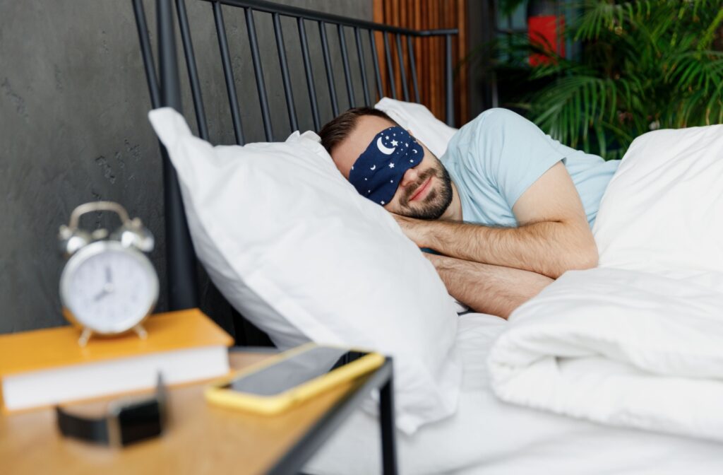 An adult peacefully starts to doze off to sleep while wearing an eye mask to help prevent dry eye symptoms.